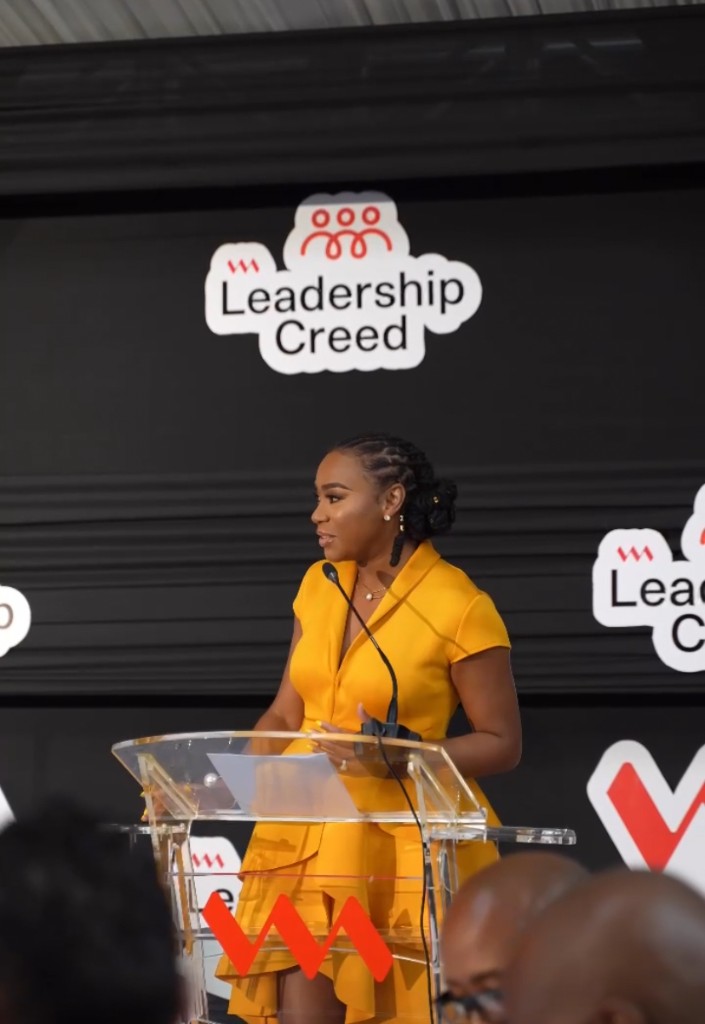 Krystal speaking at a Leadership Creed event behind a clear podium.