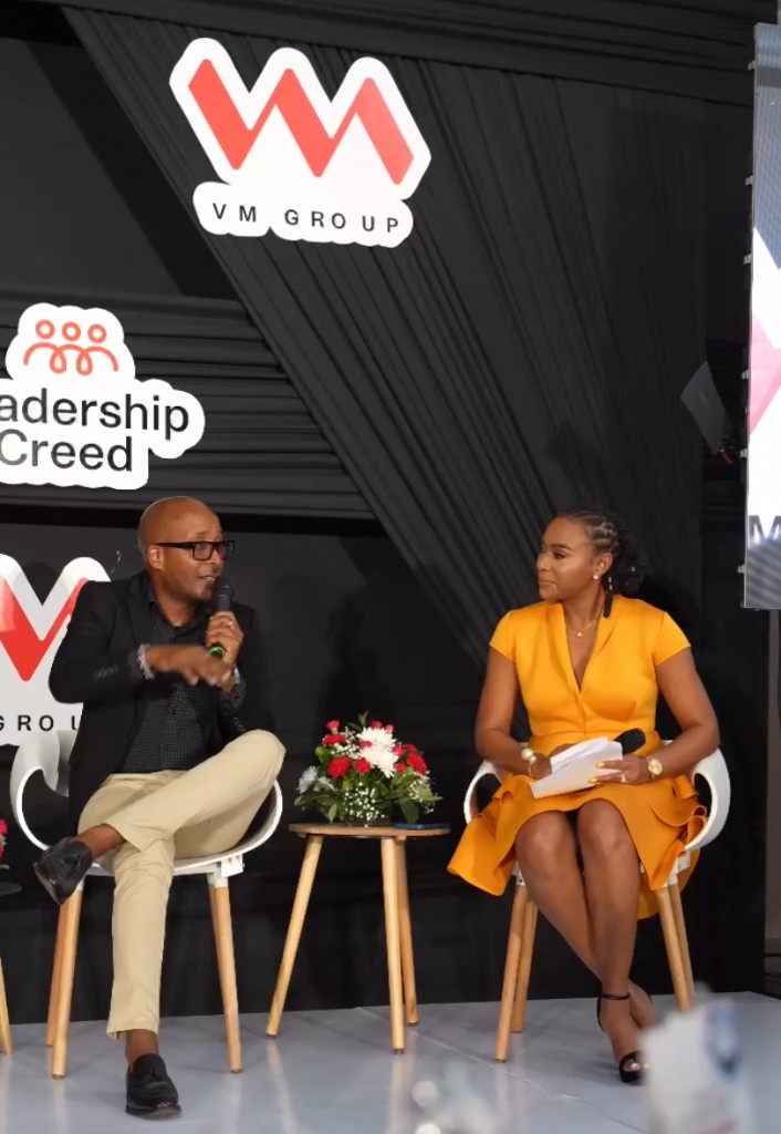 Krystal moderating a panel discussion with VM Group and Leadership Creed branding.